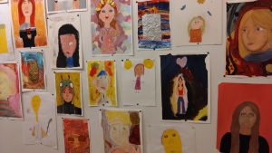 Lukuisia oppilaiden omakuvia ripustettuna toistensa lomaan